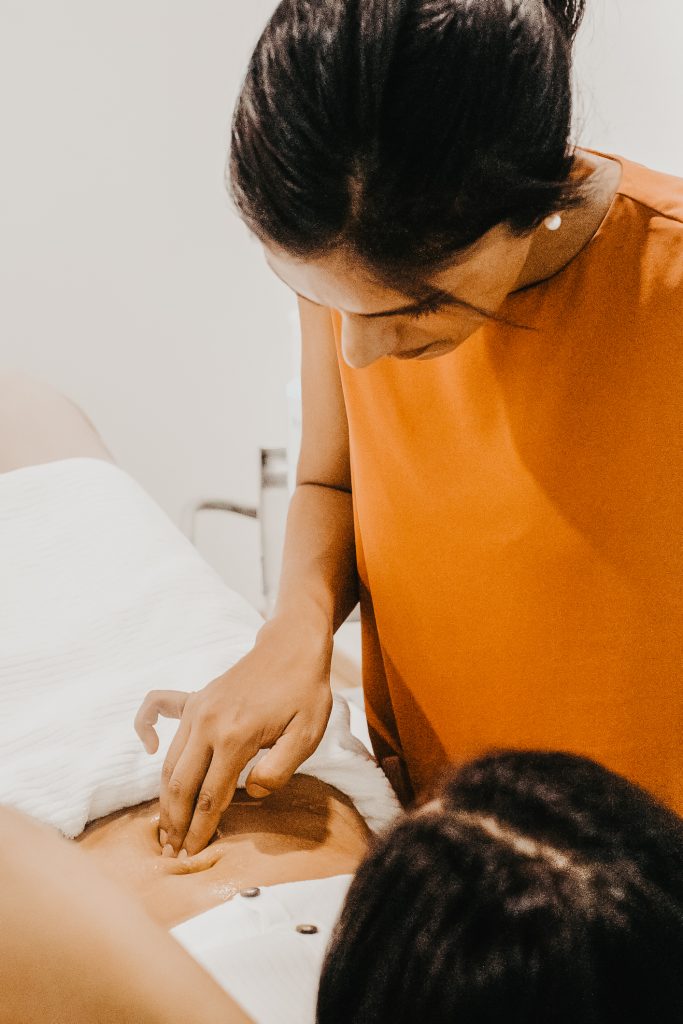 Women's health physiotherapist in Singapore assessing a c-section scar during a postnatal appointment