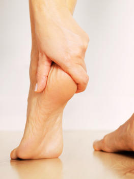 Close-up of a physiotherapist assessing the heel and plantar fascia during a plantar fasciitis treatment session in Singapore