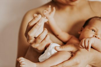 Mother holding and caring for newborn baby | Embrace Physiotherapy